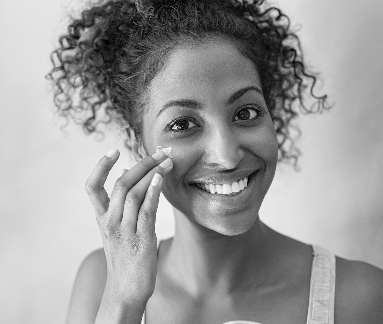 Woman Putting Facial Cream On Face, Black And White Photo