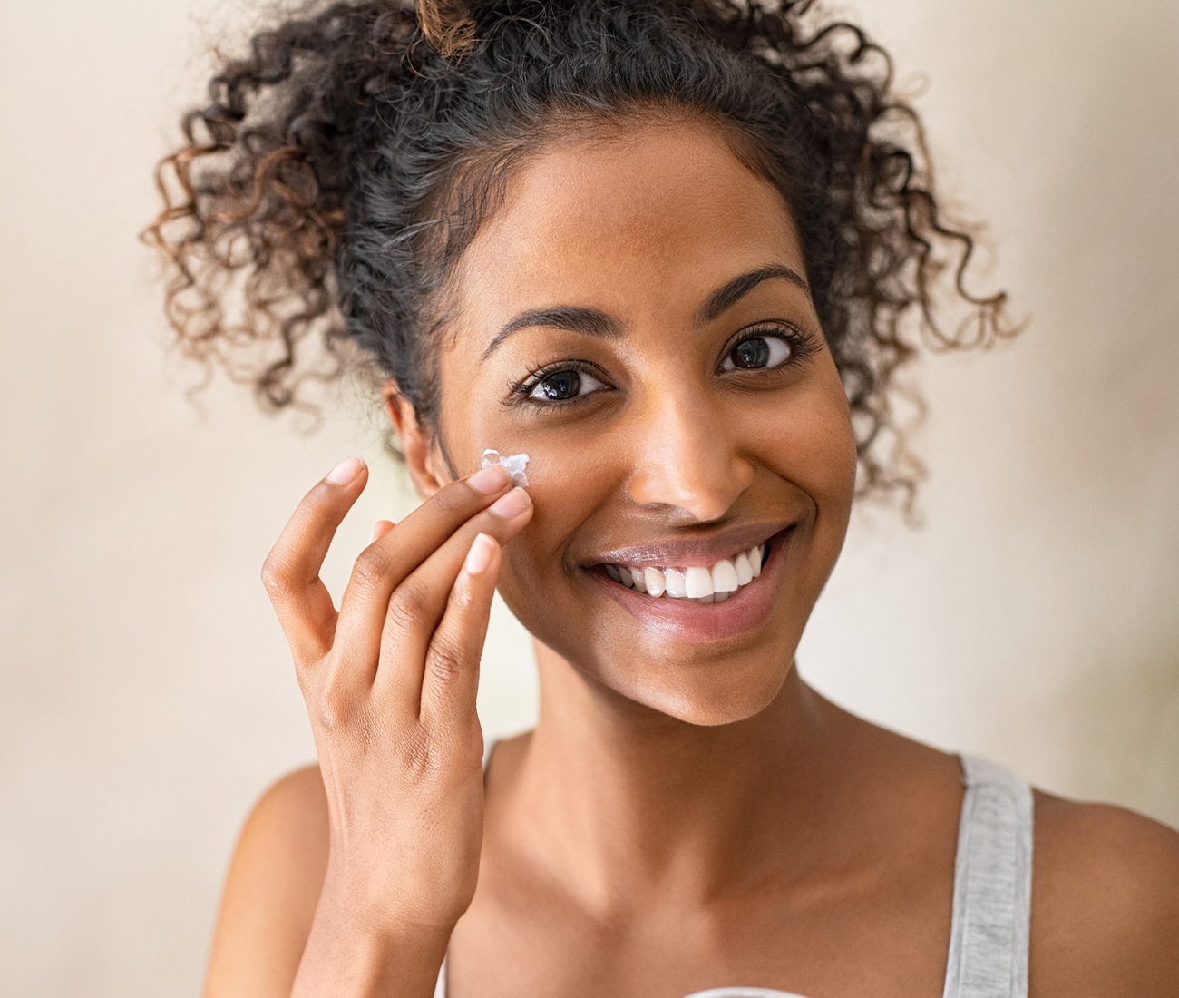 Woman Putting Facial Cream On Face