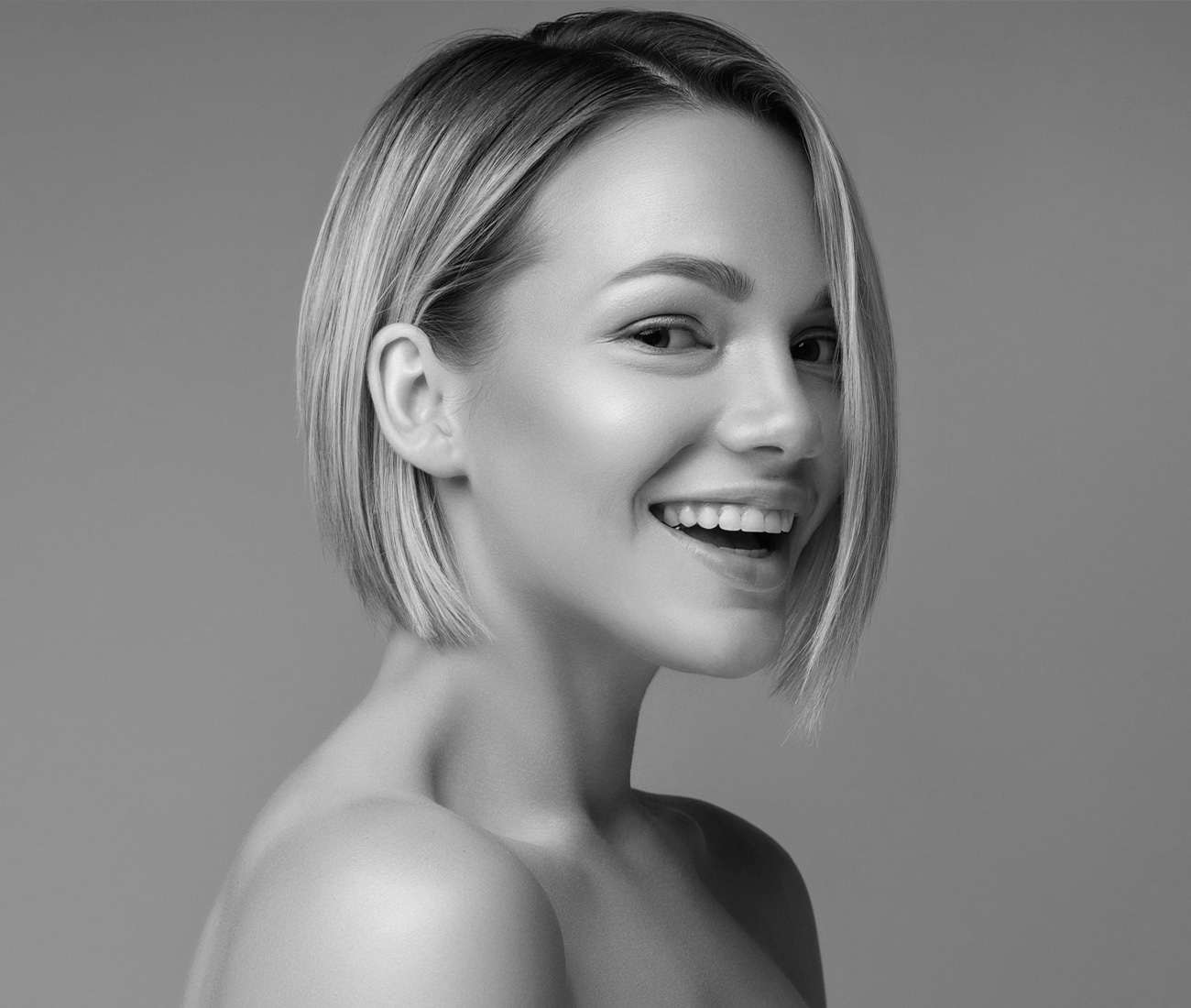 Woman With Short, Cropped Blond Hair Smiling For Camera, Black And White Photo