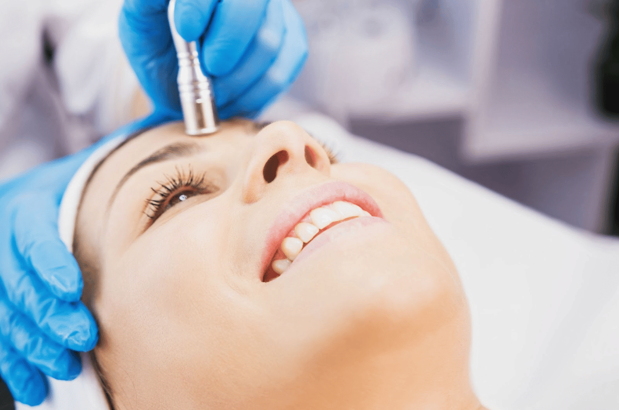 A Woman Happily Receiving A HydraFacia For Facial Rejuvenation.